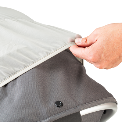 Hand pulling the mosquito net over a stroller